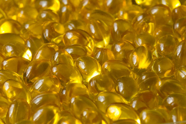 золотые фоновые капсулы крупным планом пищевой добавки масло заполнены капсулы подходящий витамин а, витамин d3, рыбий жир, омега 3, 6, 9, вечер - d3 стоковые фото и изображения