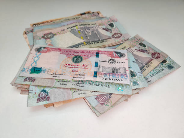 istock Money Spread on a white table | UAE Dirhams | United Arab Emirates currency | AED - Dhs | One hundred, five hundred, two hundreds and fifty bills 1214325445