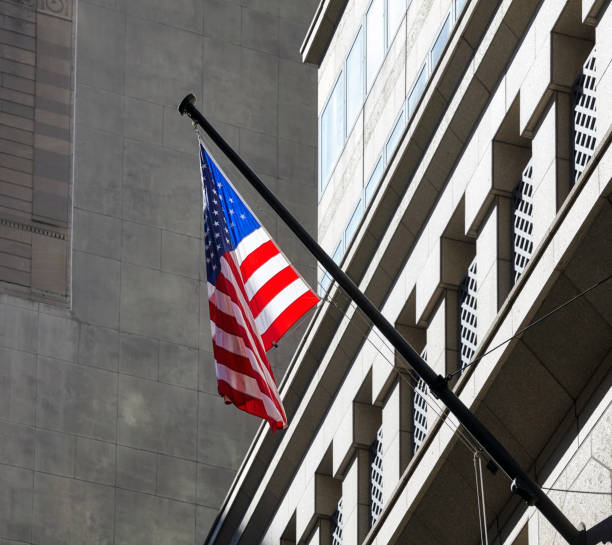 istock American flag with building facade in background, New York. 1214326353