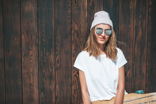istock Attractive woman standing at the wall with longboard 1214327101