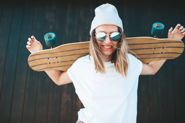 istock Attractive woman standing at the wall with longboard 1214327123