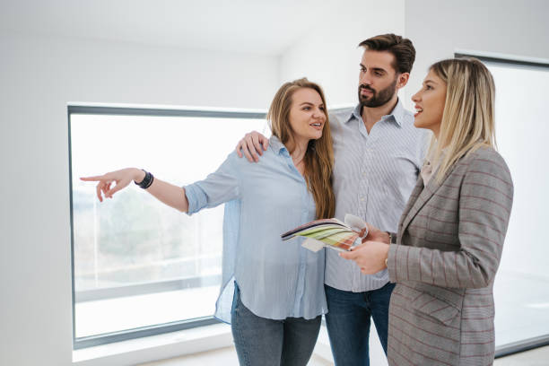 istock Cheerful couple choosing wall colors with a help of an architect 1214327212