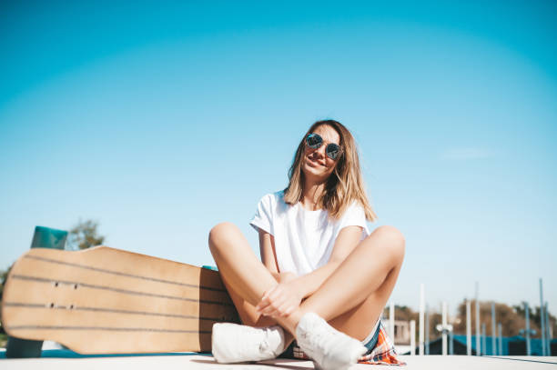 istock Attractive woman relaxing sitting on the longboard 1214327763