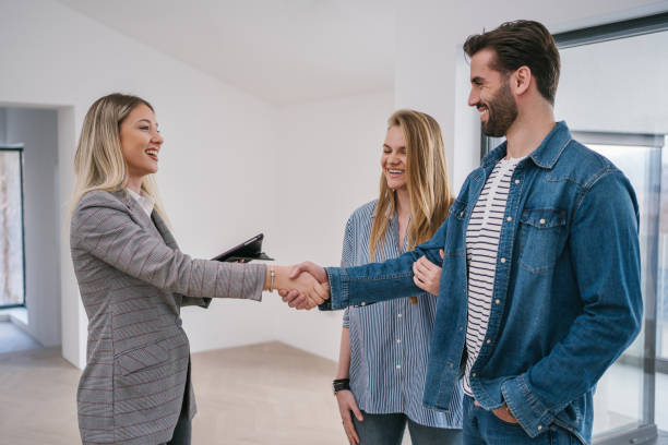 istock Young couple agreeing with a real estate agent on a house purchase 1214328863