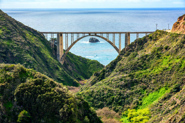 California's Scenic Highway 1 The Bixby Bridge crossing the Bixby Creek between peaks along the cliffs of one of America's most scenic routes; California State Route 1 near Big Sur. Bixby Creek stock pictures, royalty-free photos & images