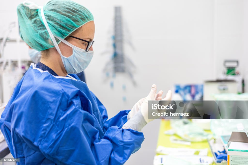 Covid-19. Female nurse puts on protective gloves. Personal protective equipment in the fight against Coronavirus disease. Nurse Stock Photo