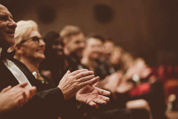 istock Happy senior man clapping in the theater, focus on hands 1214330062