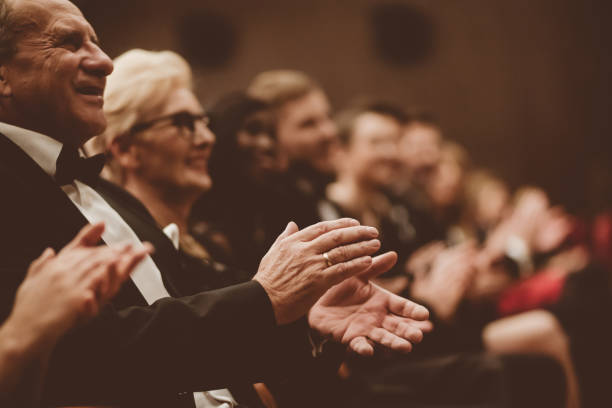 istock Happy senior man clapping in the theater, focus on hands 1214330565