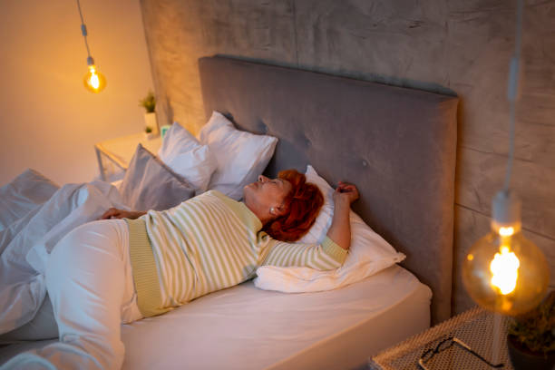 istock Senior woman stretching in bed 1214330774