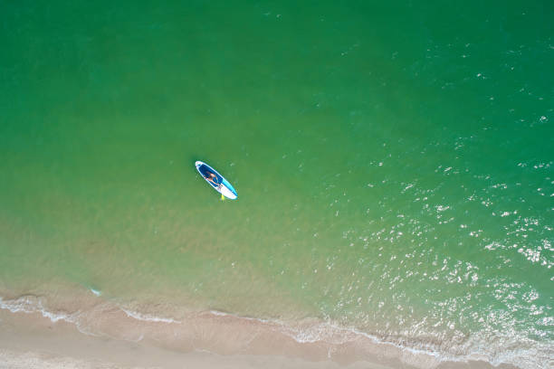 istock Young woman paddling on SUP board on the tropical beach. Active summer vacations with paddle board. 1214331537