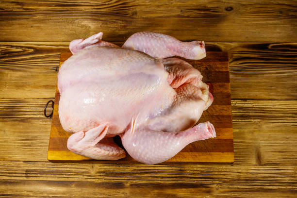 istock Raw whole chicken on a wooden table. Top view 1214333319