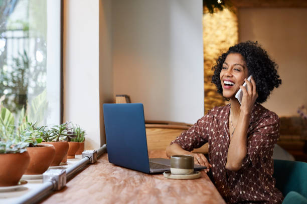 istock Cheerful woman talking through phone in cafe 1214333874