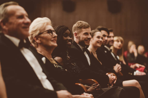 istock Smiling spectators sitting in the theater 1214335463