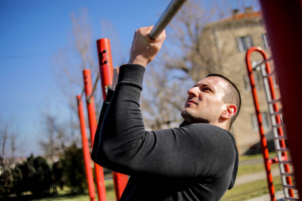 istock A young man exercises his muscles in a sports park 1214337767