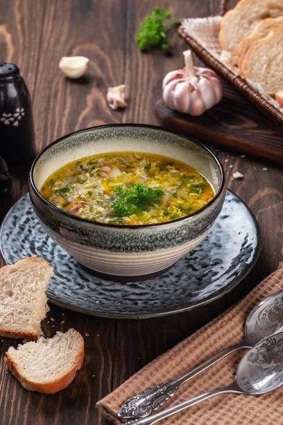 istock Fragrant chicken soup with egg with garlic and herbs on a wooden table 1214338045