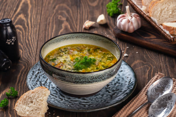 istock Fragrant chicken soup with egg with garlic and herbs on a wooden table 1214338084