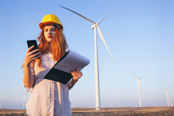 istock Young electric engineers outdoors in front of windmills 1214339521