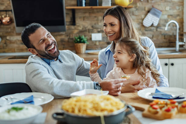 istock Young happy family having fun while having lunch at home. 1214339718