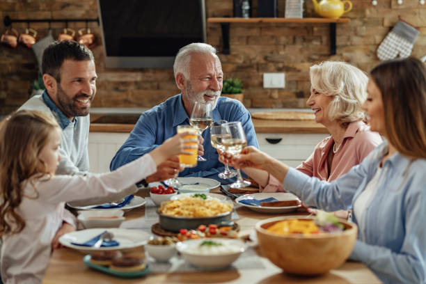istock Happy extended family toasting during lunch at dining table. 1214340959