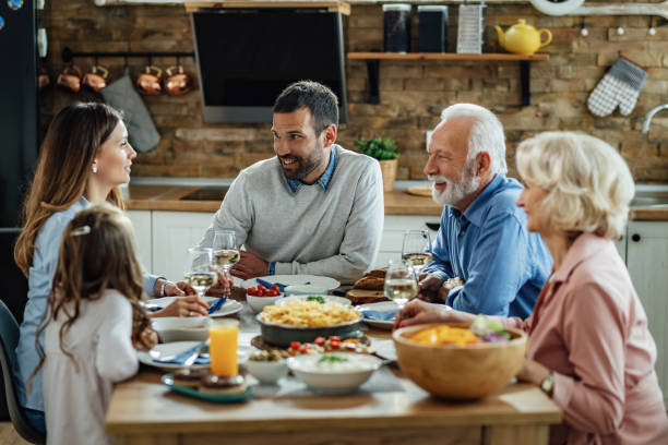 istock Happy multi-generation family enjoying in conversation during lunch at dining table. 1214341019