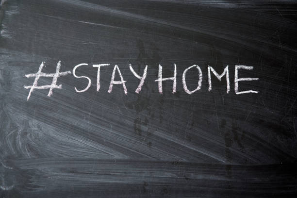 istock Hashtag stay at home. Outbreak Warning. written white chalk on blackboard in connection with epidemic of coronavirus worldwide. 1214341056