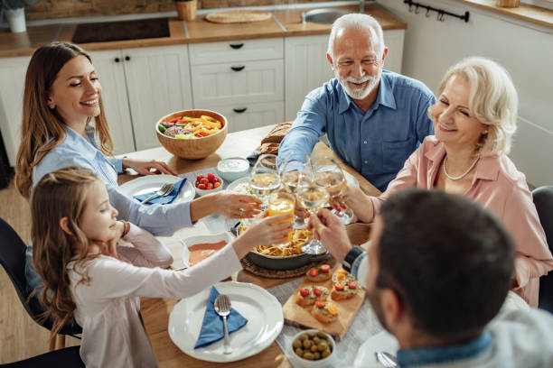 istock Happy multi-generation family having lunch and toasting at dining table. 1214341160
