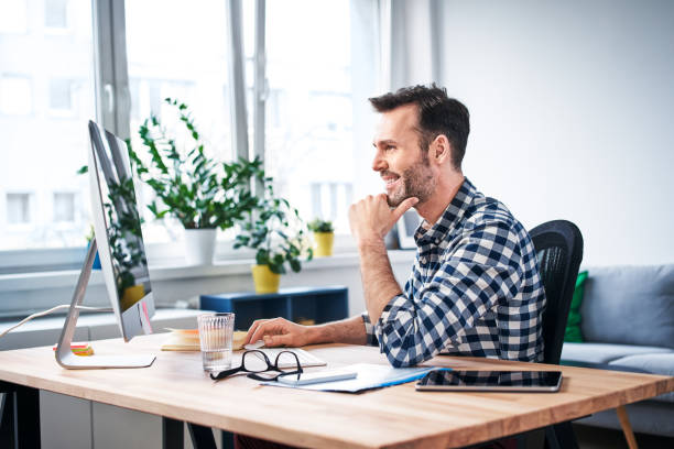 libero professionista di successo che lavora al computer mentre rimane a casa - piccolo ufficio foto e immagini stock