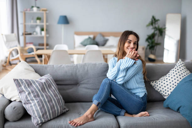 istock Relaxed smiling woman sitting on sofa at home. 1214342189