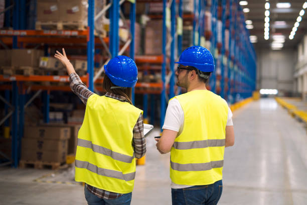 istock Warehouse workers sharing ideas for better organization and efficiency. In background shelves with products for distribution and shipping. 1214343374