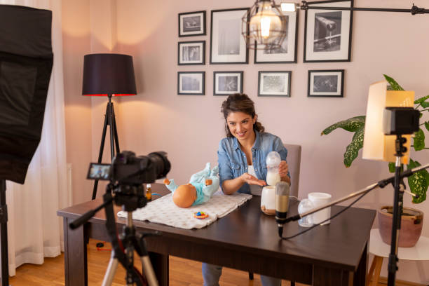 istock Female vlogger filming video about baby bottle milk heating 1214343621