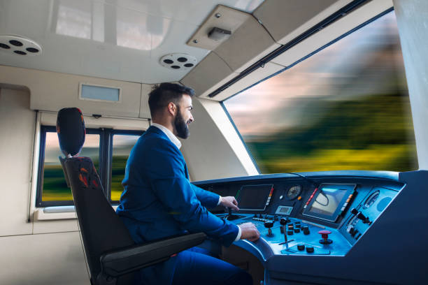 Train driver driving high speed train. Subway train moving fast. Interior cockpit view of subway driver operating train. Professional man driver in uniform sitting in train cabin. Dashboard with commands and monitors in front of him. train interior stock pictures, royalty-free photos & images