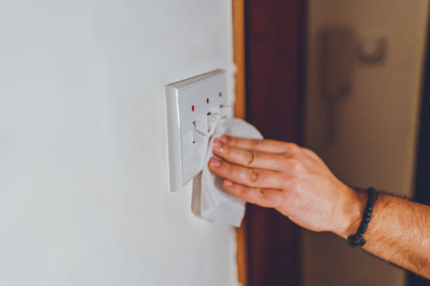 istock Disinfecting the light switch against corona virus 1214346168