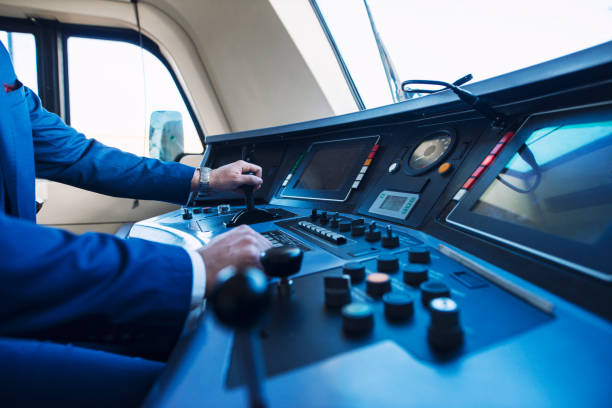 Cockpit view of high speed subway train and an unrecognizable train driver. Train dashboard with buttons and monitors. Engine driver hands operating train. Driver's hands pushing up the lever and accelerating the train. train interior stock pictures, royalty-free photos & images