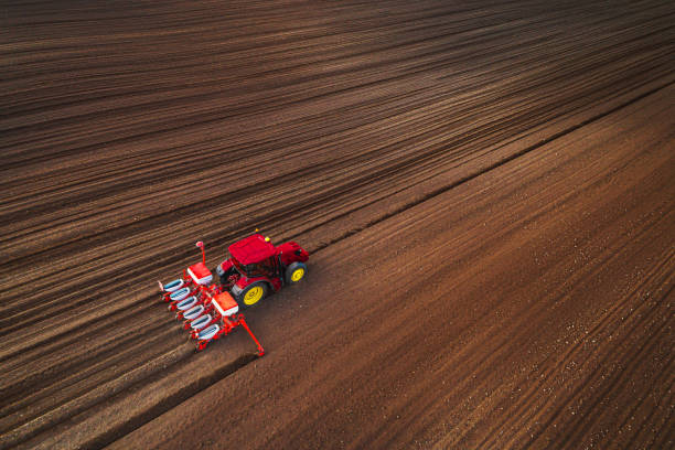 Farmer in tractor preparing farmland with seedbed for the next year