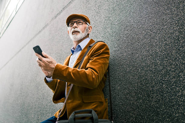 istock Senior Man Outdoors with glasses texting on phone 1214350920