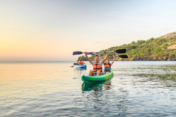 istock Smiling Kayakers with Paddles Held Over Their Heads 1214353627