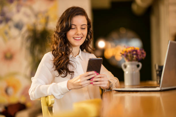 istock Woman using smart phone and laptop at cafe 1214353637