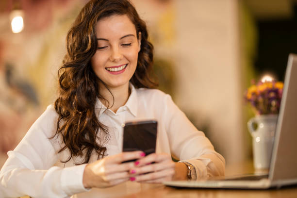 istock Woman using smart phone and laptop at cafe 1214354253