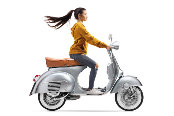 istock Young female on a vintage scooter riding fast 1214354962