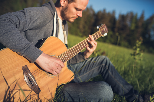 Man playing acoustic guitar outdoors