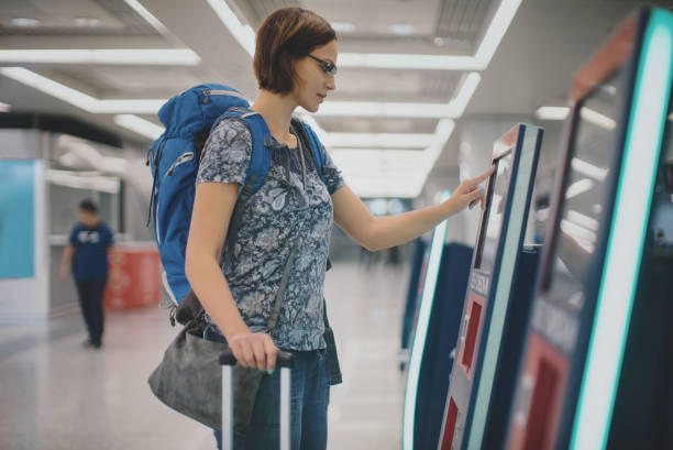 istock Woman using self service check in at the airport. 1214356851