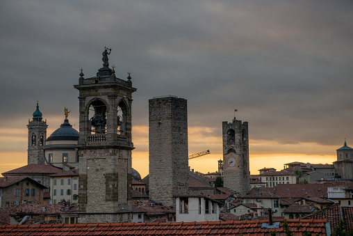 Bergamo at sunset in the old city with towers and bell tower