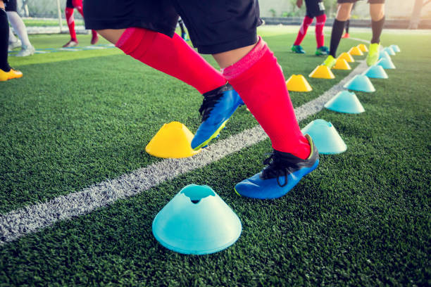 istock Soccer player Jogging and jump between cone markers on green artificial turf 1214364698