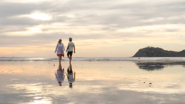 marcher de couples le long de la plage au lever du soleil - 16747 photos et images de collection