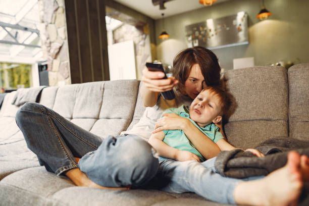 istock Mother and little son sitting and watching TV 1214367916