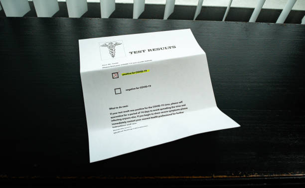 istock COVID-19 Positive Test Result letter on desk 1214370207