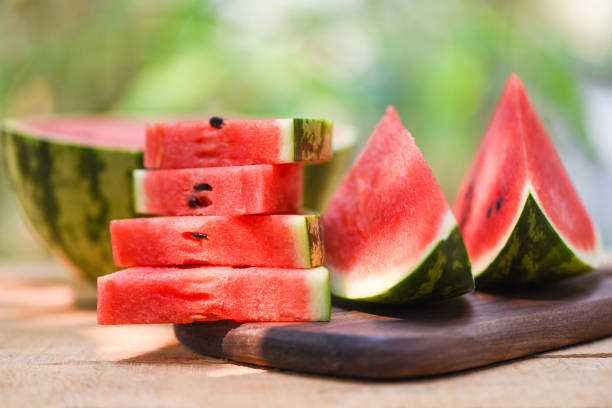 melancia fatiada em madeira e fundo da natureza - feche as peças de melancia fresca sinuosa fruta tropical de verão - watermelon fruit summer portion - fotografias e filmes do acervo