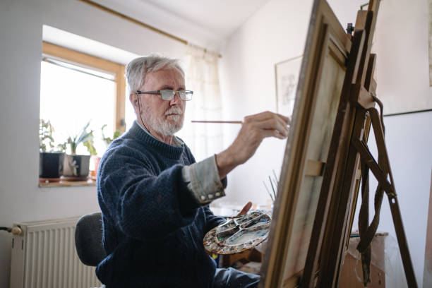 istock Serious senior painter painting in a art studio 1214373134