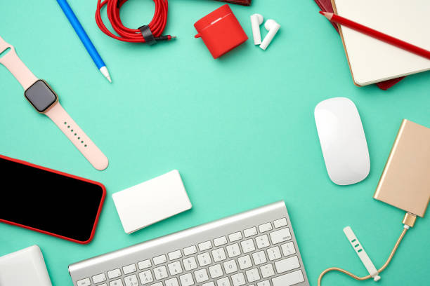 keyboard, golden power bank with cable, red smartphone with blank black screen