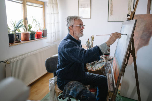 istock Creative senior painting at home 1214373243